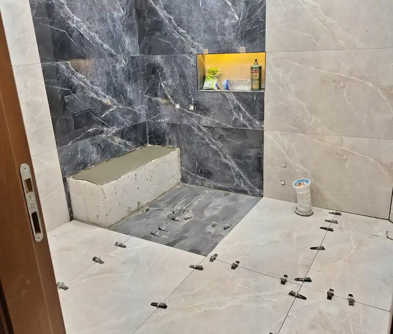 Döşemesi süren banyoda mermer görünümlü duvar